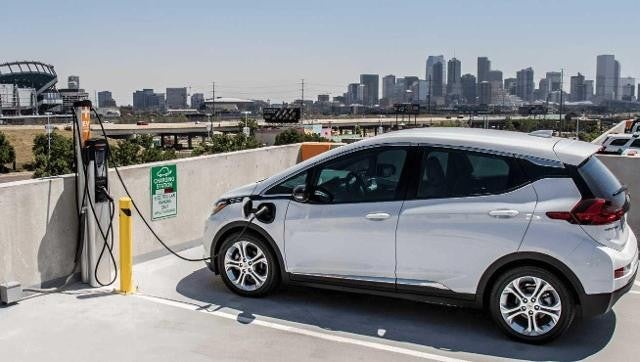 white ev standing in ev station and charging